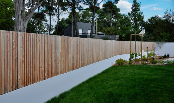 Clôture en liteaux bois sur muret enduit